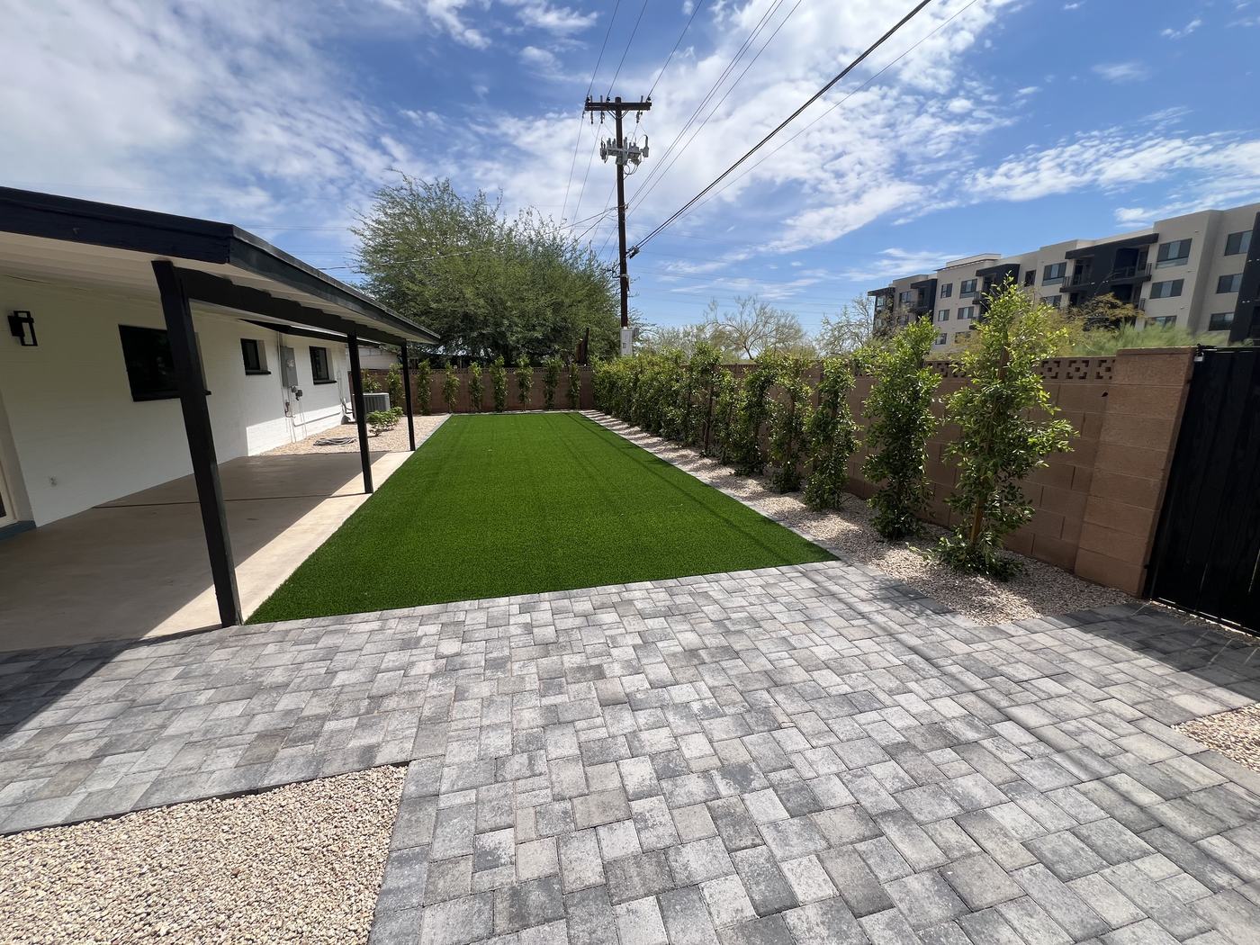 Back yard with turf, pavers, and hedge
